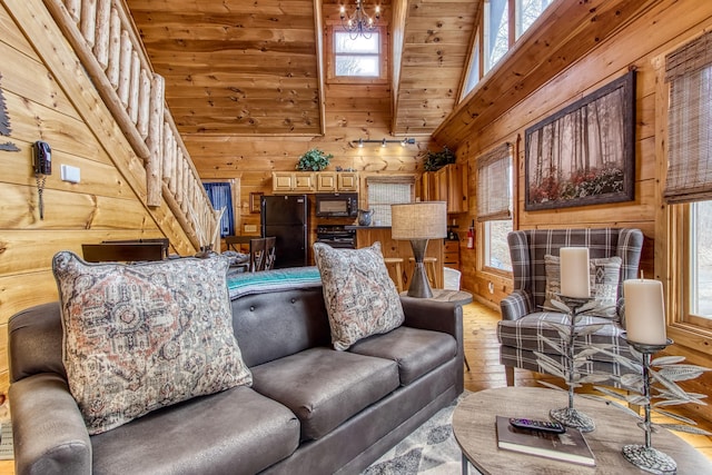 living room featuring high vaulted ceiling, plenty of natural light, and wooden walls