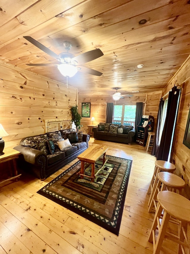 living room featuring ceiling fan, light hardwood / wood-style flooring, and wood ceiling