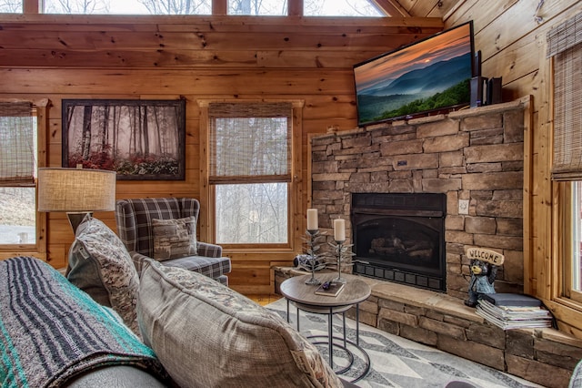 living room with plenty of natural light, wood walls, lofted ceiling, and a fireplace