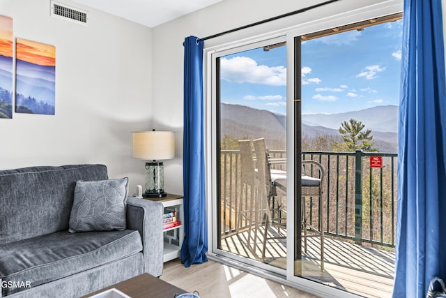 living area with visible vents, wood finished floors, and a mountain view