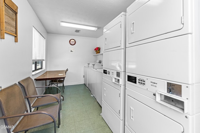 shared laundry area featuring visible vents, baseboards, stacked washer / drying machine, a textured ceiling, and separate washer and dryer