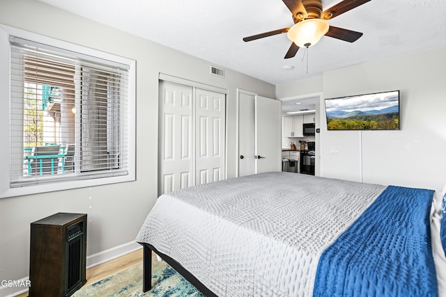 bedroom with a closet, visible vents, ceiling fan, light wood-type flooring, and baseboards