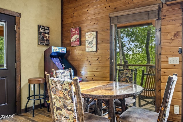 dining area featuring wooden walls and wood finished floors