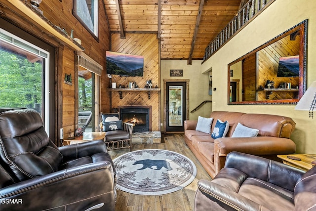 living room with a fireplace, wood walls, wood finished floors, wooden ceiling, and beamed ceiling