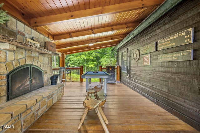 wooden terrace featuring an outdoor stone fireplace