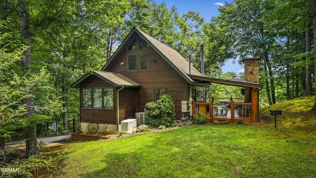 view of home's exterior featuring a yard, a chimney, and central air condition unit