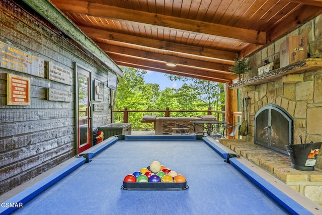 rec room featuring an outdoor stone fireplace, wooden ceiling, billiards, and beam ceiling
