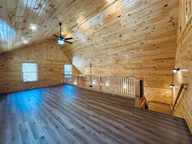 additional living space with wooden walls, lofted ceiling, ceiling fan, wood ceiling, and dark wood-type flooring