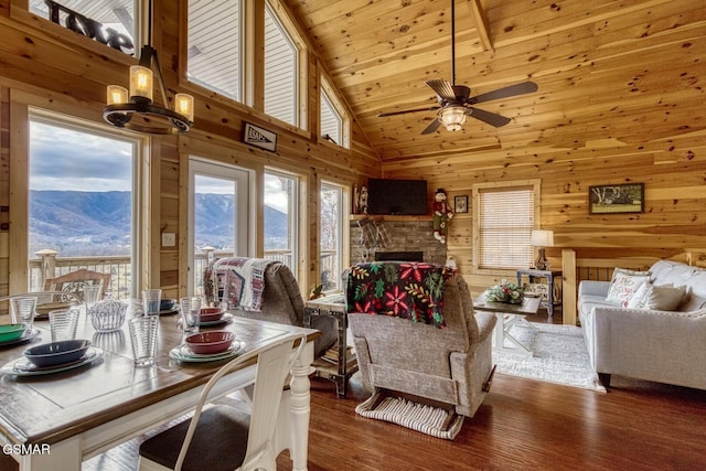 interior space featuring a mountain view, wooden walls, ceiling fan, and dark wood-type flooring