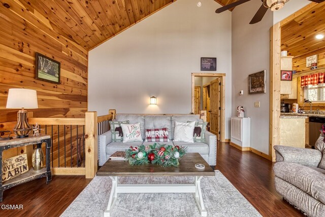 living room featuring wooden walls, dark wood-type flooring, high vaulted ceiling, and wood ceiling