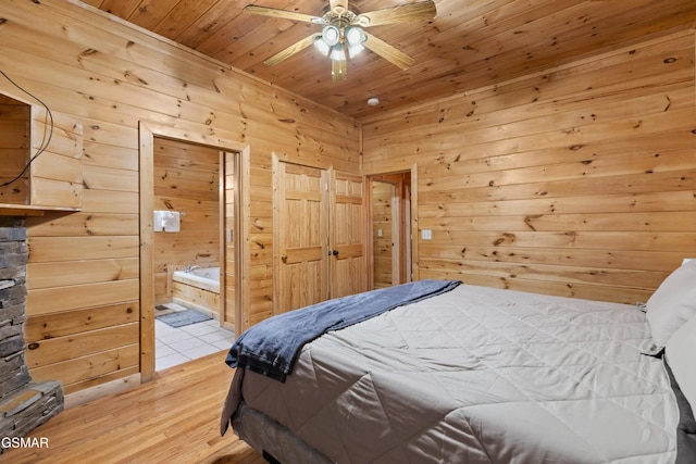 bedroom featuring ensuite bathroom, wooden ceiling, wooden walls, and light hardwood / wood-style floors