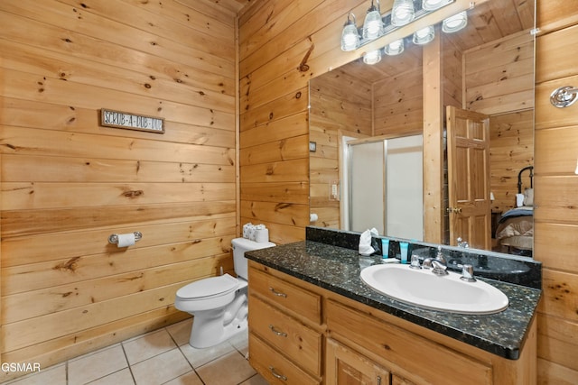 bathroom with tile patterned floors, toilet, vanity, wooden walls, and a shower with door