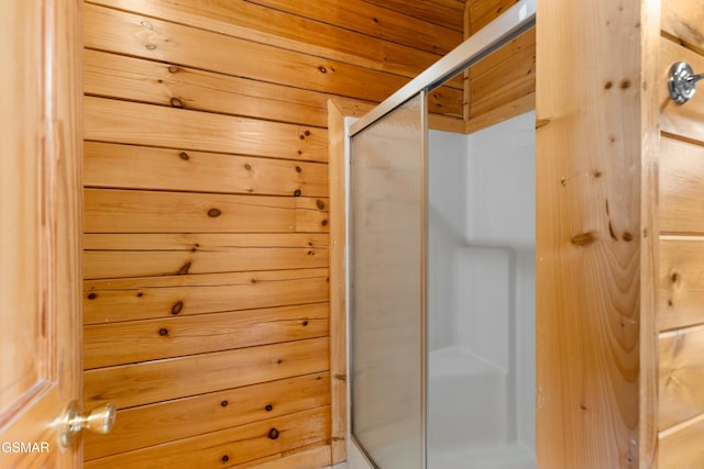 bathroom with wooden walls and an enclosed shower