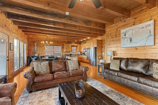 living room with beam ceiling, light hardwood / wood-style flooring, wooden ceiling, and wood walls