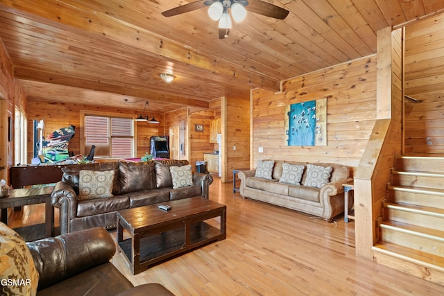 living room featuring wooden walls, beamed ceiling, ceiling fan, wood ceiling, and light hardwood / wood-style flooring