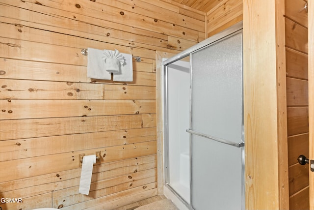 bathroom with wooden walls and walk in shower