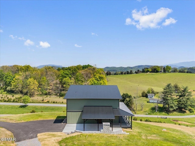 exterior space featuring a mountain view, a rural view, and a yard