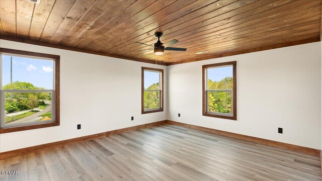 spare room featuring a ceiling fan, baseboards, light wood-style floors, and wood ceiling