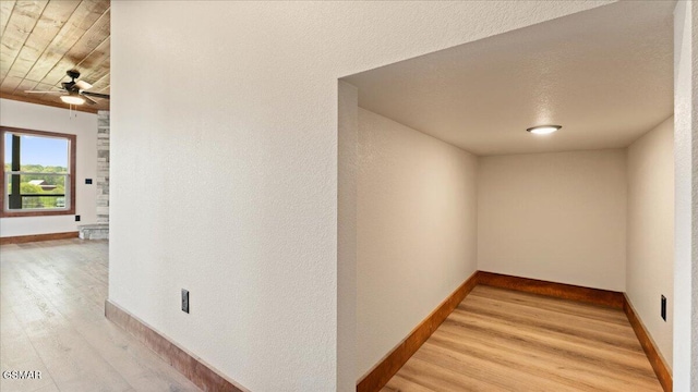 hall featuring baseboards and light wood-type flooring
