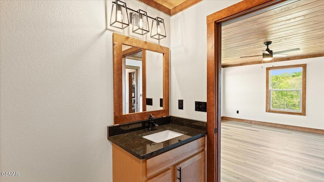 bathroom with a textured wall, vanity, and a ceiling fan