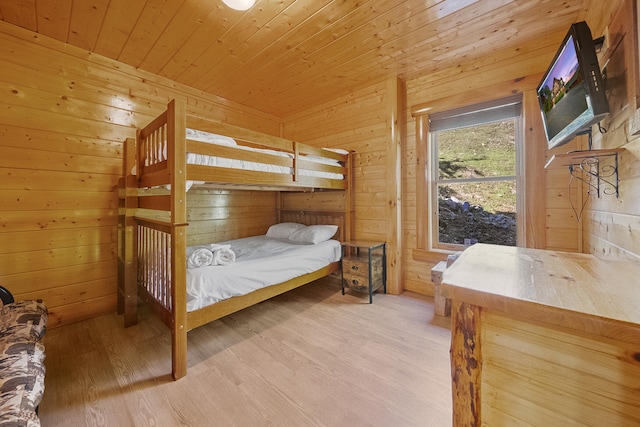 bedroom with wood walls, light hardwood / wood-style flooring, and wooden ceiling