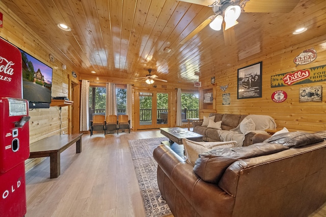 living room featuring wood-type flooring, wooden walls, ceiling fan, and wood ceiling