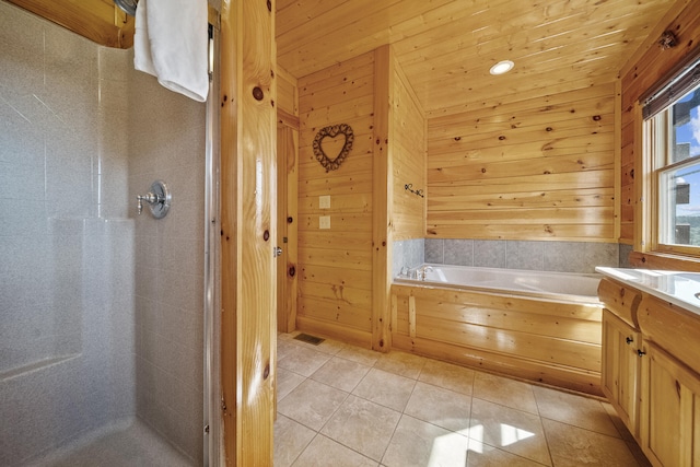 bathroom featuring tile patterned flooring, vanity, plus walk in shower, and wood walls