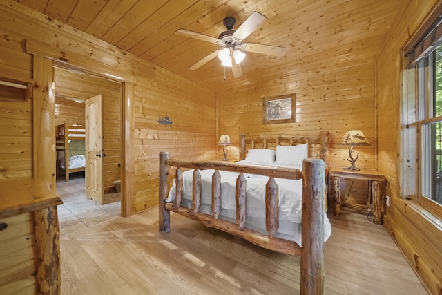 bedroom featuring wood ceiling, wooden walls, light hardwood / wood-style floors, and ceiling fan