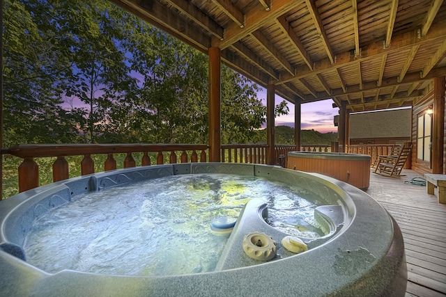 deck at dusk with a hot tub