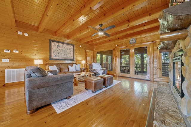 living room with beamed ceiling, wood ceiling, a fireplace, and light hardwood / wood-style floors