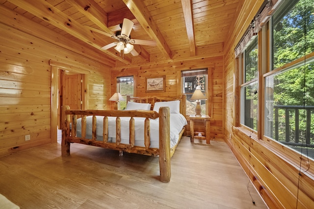 bedroom with wooden walls, wooden ceiling, beamed ceiling, and light wood-type flooring