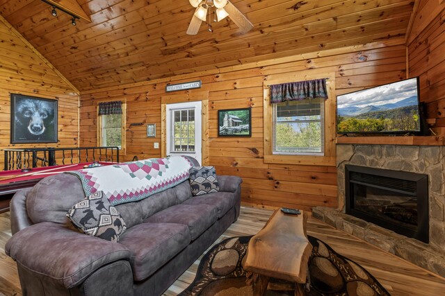 living room featuring wooden ceiling, lofted ceiling, track lighting, wooden walls, and ceiling fan