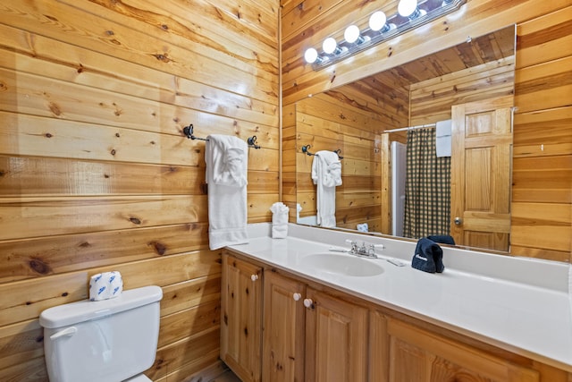 bathroom with curtained shower, wood walls, vanity, and toilet