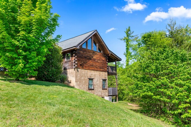 view of side of property with a yard and a balcony