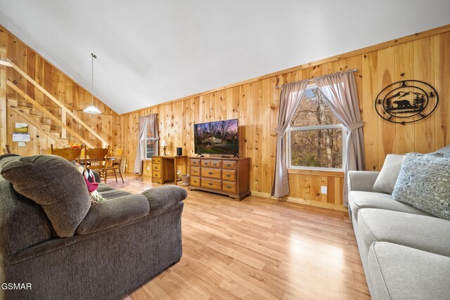 living room featuring hardwood / wood-style floors, wooden walls, and vaulted ceiling