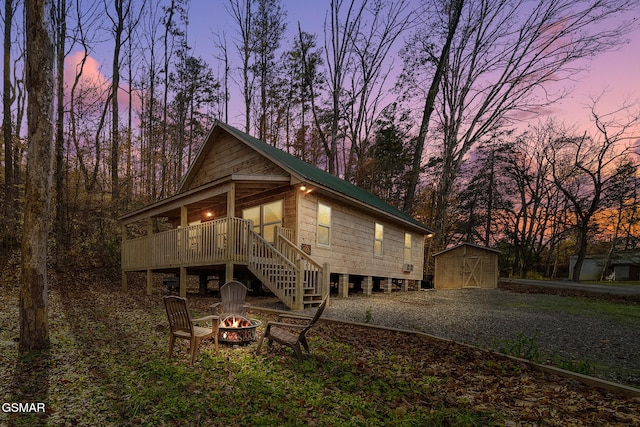 exterior space with a fire pit, a storage unit, and a deck