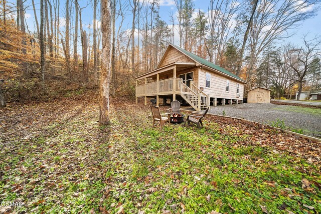 exterior space featuring an outdoor structure, a fire pit, and a deck