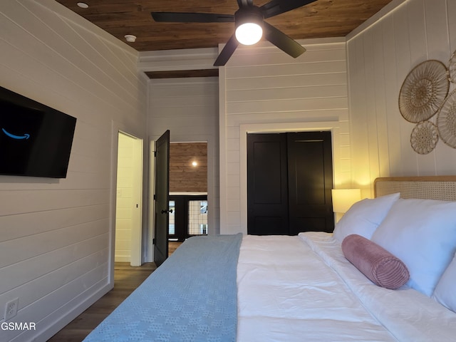 bedroom featuring wood walls, a ceiling fan, wood finished floors, and wooden ceiling