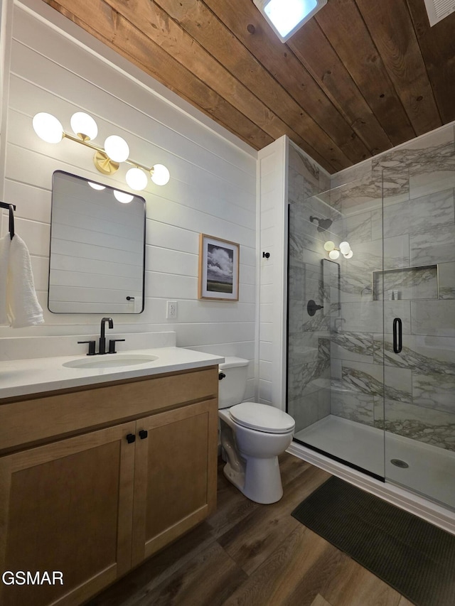 bathroom featuring vanity, wood finished floors, toilet, wood ceiling, and a shower stall