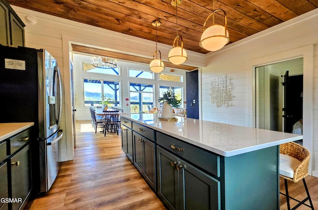 kitchen featuring wooden walls, wooden ceiling, light wood-style flooring, and stainless steel fridge with ice dispenser