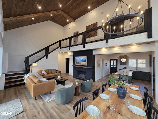interior space featuring wood ceiling, a fireplace, wood finished floors, stairway, and high vaulted ceiling