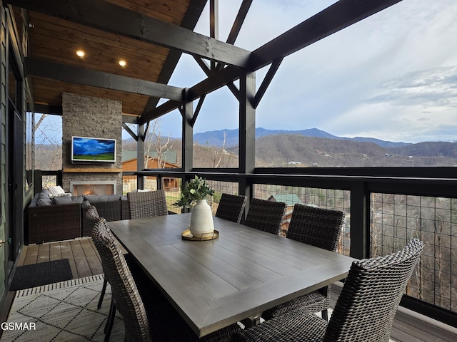 wooden terrace featuring an outdoor living space with a fireplace and outdoor dining area