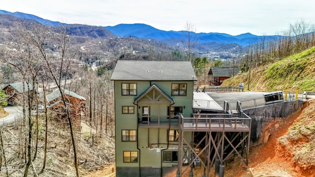 rear view of house featuring a deck with mountain view