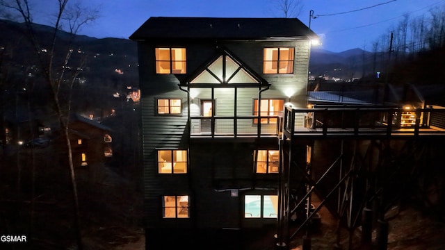 rear view of house with a mountain view and a balcony