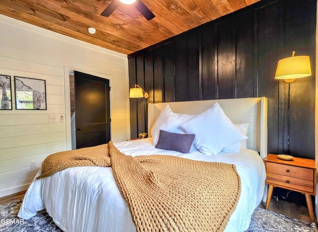 bedroom with ceiling fan, wood finished floors, wooden walls, and wooden ceiling