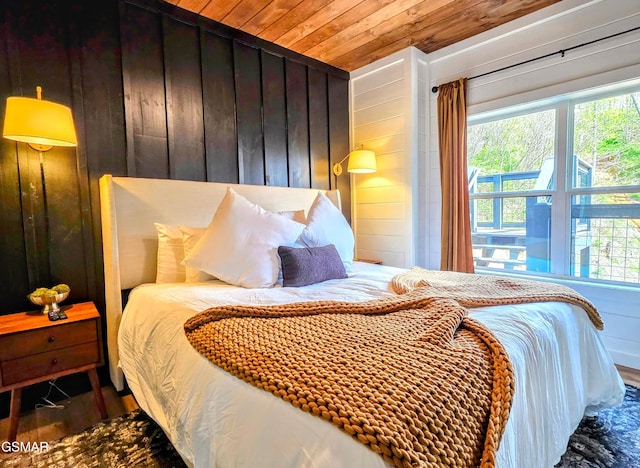 bedroom featuring wooden walls, wooden ceiling, and wood finished floors