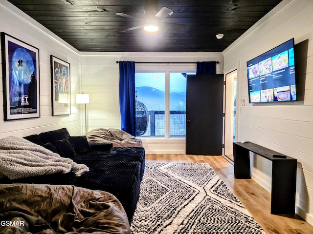 living area with crown molding, a ceiling fan, wooden ceiling, and light wood finished floors