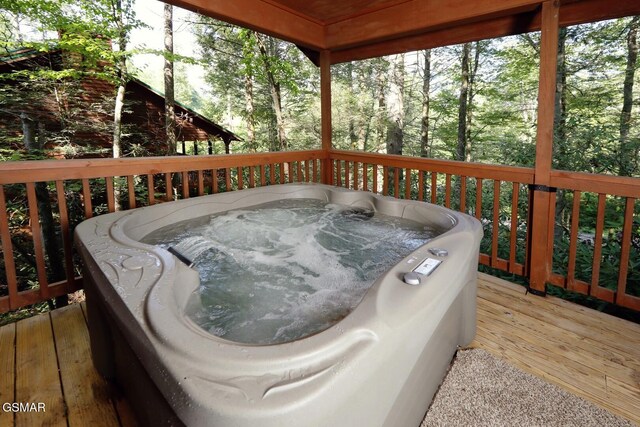 wooden terrace featuring a hot tub