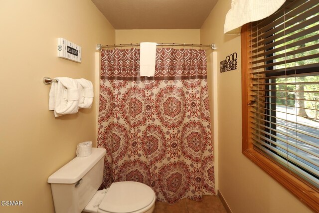 bathroom featuring tile patterned flooring, toilet, and a shower with shower curtain