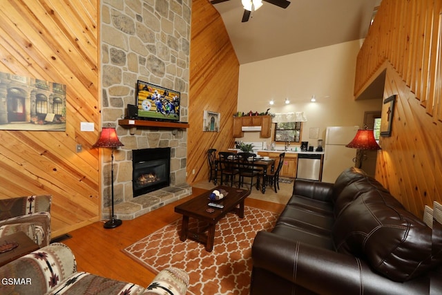 living room with high vaulted ceiling, sink, ceiling fan, a fireplace, and wood-type flooring